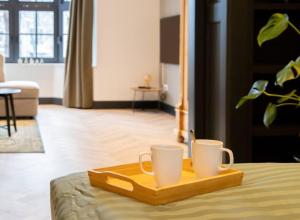 a tray with two coffee mugs on top of a bed at PRIVATE APPARTMENT 60m2 - CENTRE TOP LOCATION in Amsterdam