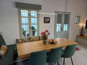 a dining room table with chairs and a vase of flowers at Casa Petra in Nea Kydonia