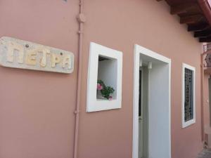 a pink building with a sign and a flower window at Casa Petra in Nea Kydonia