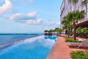 名古屋的住宿－Batam Marriott Hotel Harbour Bay，一座棕榈树游泳池和一座建筑