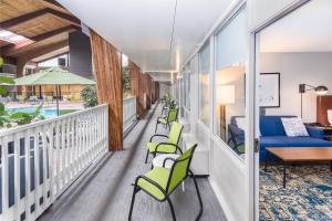 a balcony with green chairs and a couch at Four Points by Sheraton Eastham Cape Cod in Eastham