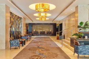 a lobby with a long hallway with chairs and a chandelier at Sheraton Athlone Hotel in Athlone