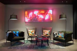 a room with two chairs and a painting on the wall at Moxy Bristol in Bristol