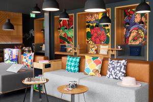 a living room with a couch with colorful pillows at Moxy Bristol in Bristol