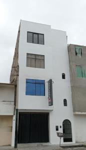 a white building with a black gate at Hostal Venus - Nueva Imagen in Huacho