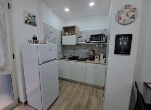 a small kitchen with a refrigerator and a sink at Domus de loco sano in Castellammare di Stabia +22 photos