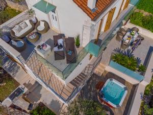 an overhead view of a house with a swimming pool at Uniquely designed Villa Ivana with outdoor Jacuzzi nearby the pebble Banje beach at the Island of Solta in Rogač