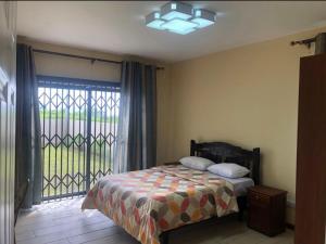 a bedroom with a bed and a large window at Grand View Villa in Pont Colville