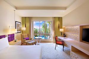 a hotel room with a bed and a desk and a window at ITC Maratha, a Luxury Collection Hotel, Mumbai in Mumbai