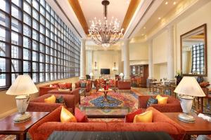 a hotel lobby with orange couches and a chandelier at ITC Maratha, a Luxury Collection Hotel, Mumbai in Mumbai