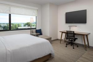 a hotel room with a bed and a desk and a television at Element Seattle Sea-Tac Airport in Tukwila