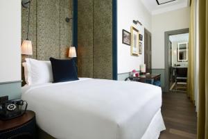 シンガポールにあるMaxwell Reserve Singapore, Autograph Collectionのベッドルーム1室(大きな白いベッド1台付)、廊下が備わります。