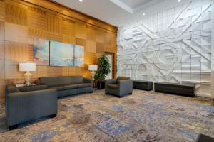 a lobby with couches and chairs and a wall at Best Western Premier Chateau Granville Hotel & Suites & Conference Centre in Vancouver