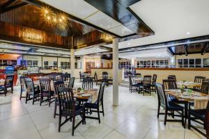 un comedor con mesas y sillas en un restaurante en Protea Hotel by Marriott Klerksdorp, en Klerksdorp