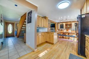 a large kitchen with wooden cabinets and a dining room at Roscommon Vacation Rental about 1 Mi to Higgins Lake! in Roscommon