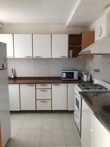 a kitchen with white cabinets and a stove top oven at Amplio, luminoso y centrico dep. 3 dorm in Concordia