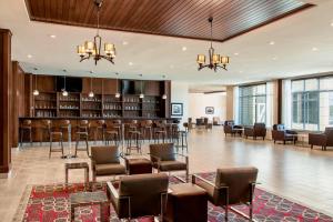 a lobby with a bar with chairs and tables at Four Points by Sheraton Grande Prairie in Grande Prairie