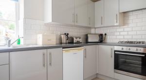 a white kitchen with white cabinets and appliances at Ullswater at the Graythwaite Estate in Ambleside