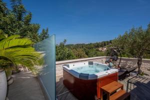 eine Badewanne auf einer Terrasse in der Unterkunft Uniquely designed Villa Ivana with outdoor Jacuzzi nearby the pebble Banje beach at the Island of Solta in Rogač