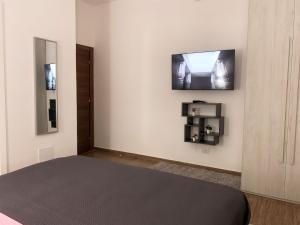 a bedroom with a bed and a tv on a wall at R Home in Ischia
