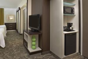 Habitación de hotel con TV y dormitorio en SpringHill Suites by Marriott Toronto Vaughan, en Vaughan