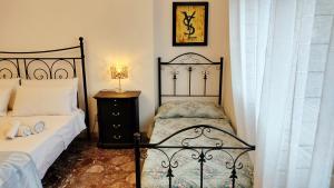a bedroom with two beds and a table with a lamp at LA BARONESSA apartment- vicinissimo al policlinico in Messina +37 photos