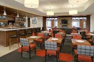 um restaurante com mesas e cadeiras e um bar em Four Points by Sheraton Cambridge Kitchener, Ontario em Cambridge