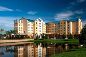 a hotel with a lake in front of it at Fairfield Inn Suites by Marriott Orlando At SeaWorld in Orlando