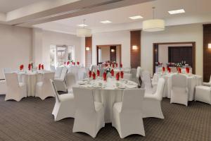 - une salle de banquet avec des tables blanches et des chaises blanches dans l'établissement Four Points by Sheraton Cambridge Kitchener, Ontario, à Cambridge