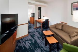 a living room with a couch and a desk at Fairfield Inn Suites by Marriott Orlando At SeaWorld in Orlando