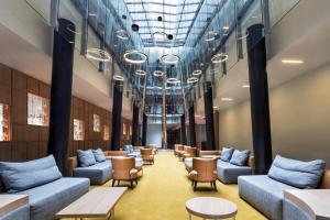 a waiting room with blue couches and tables at Four Points by Sheraton Ljubljana Mons in Ljubljana