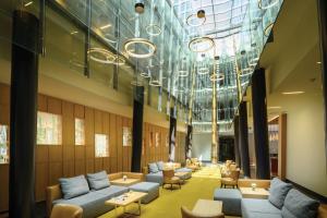 a lobby with couches and tables and a glass ceiling at Four Points by Sheraton Ljubljana Mons in Ljubljana