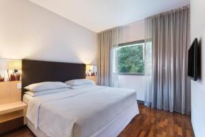 a bedroom with a large white bed and a window at Four Points by Sheraton Ljubljana Mons in Ljubljana +85 photos