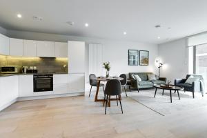cocina y sala de estar con mesa y sillas en Khayat Homes - The Canex - One Bed, en Londres