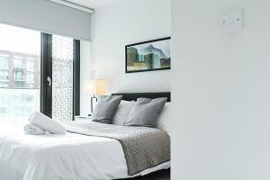 Un dormitorio blanco con una cama blanca y una ventana en Khayat Homes - The Canex - One Bed, en Londres