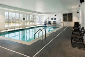 a large indoor pool with chairs and a table at Four Points by Sheraton Albany in Albany