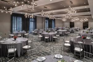 um salão de banquetes com mesas, cadeiras e lustres em Residence Inn by Marriott Boston Natick em Natick