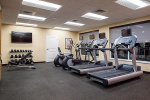 un gimnasio con máquinas de correr y TV de pantalla plana en TownePlace Suites by Marriott Charleston-West Ashley en Charleston