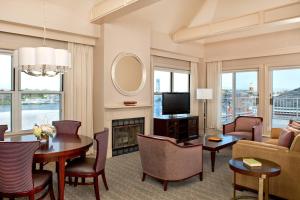 a living room with a couch and a table and a fireplace at Sheraton Portsmouth Harborside Hotel in Portsmouth