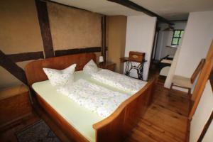 ein Schlafzimmer mit einem Bett mit einem Kopfteil aus Holz in der Unterkunft Gerberhaus Cottbus in Cottbus