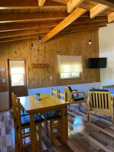 comedor con mesa de madera y sillas en Cabaña Bigua en San Martín de los Andes