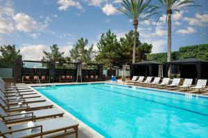 a swimming pool with lounge chairs and palm trees at San Diego Marriott Del Mar in San Diego