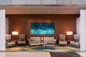 a lobby with a couch and chairs and a painting at JW Marriott Los Angeles L.A. LIVE in Los Angeles