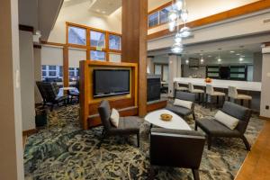 sala de estar con TV, mesa y sillas en Residence Inn by Marriott Hazleton, en Hazleton