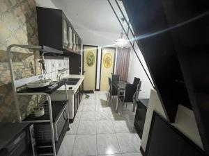 uma cozinha com armários pretos e uma mesa e cadeiras em HOUSE FOR RENT IN LASPINAS em Manila