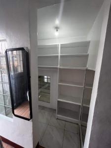 um quarto com prateleiras brancas e um espelho em HOUSE FOR RENT IN LASPINAS em Manila