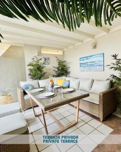 a living room with a couch and a table at Ático frente al mar, PataconaBlue, complejo vacacional in Valencia