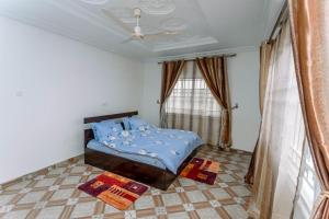 een slaapkamer met een blauw bed en een raam bij Tadi, West Coast Lane in Inchaban