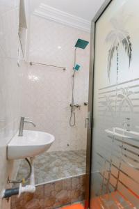 een badkamer met een douche en een wastafel bij Tadi, West Coast Lane in Inchaban