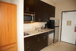 a kitchen with a sink and a refrigerator at TownePlace Suites by Marriott Hobbs in Hobbs